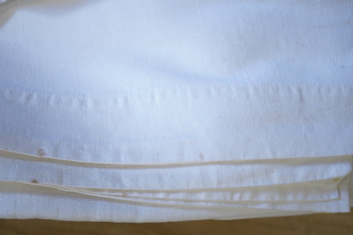 Six French provincial linen sheets each with a red cross stitched monogram to the turn back.